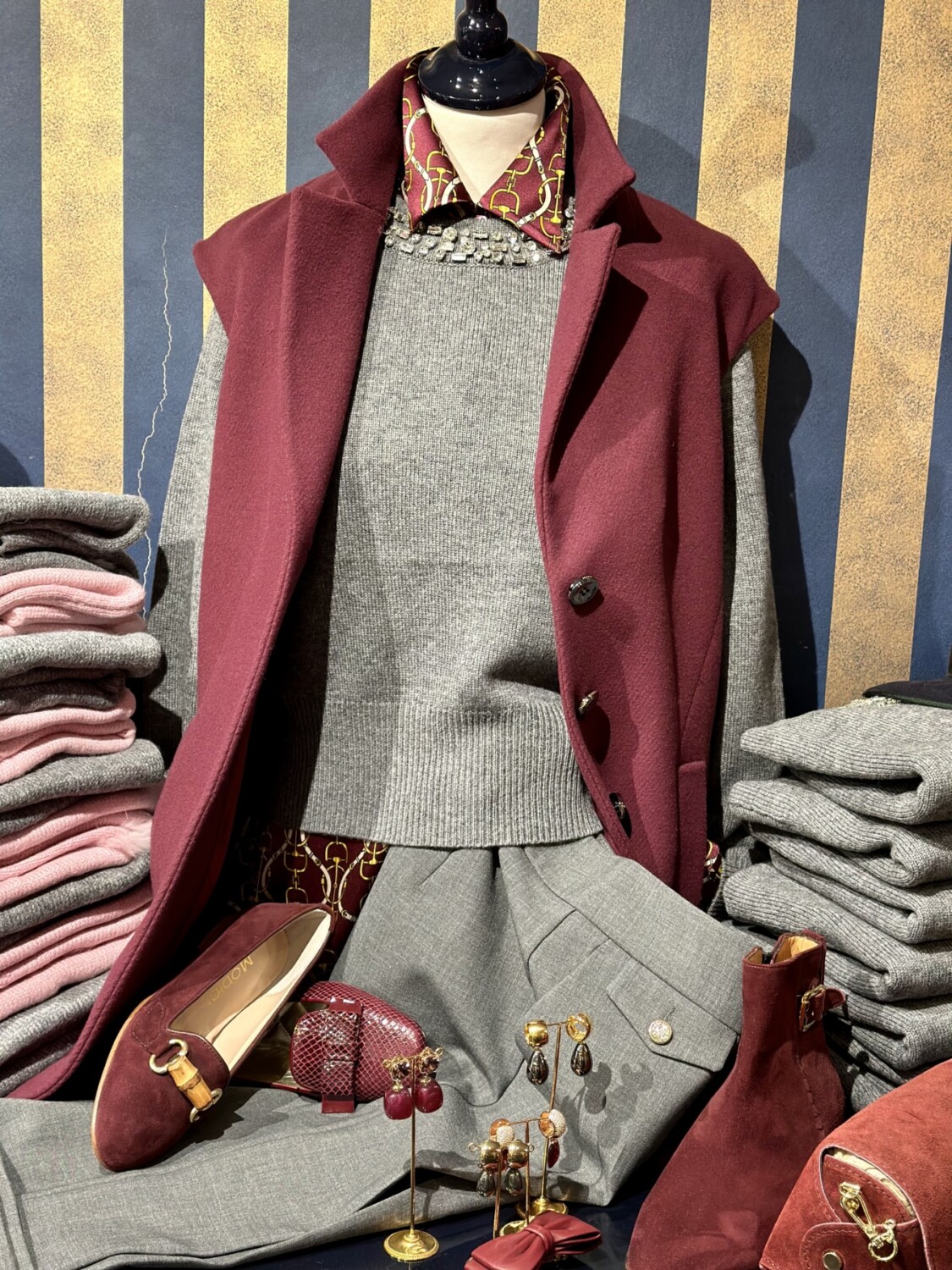 Luxueuze damesmode met stijlvolle winterkleding en accessoires in diepe bordeaux- en grijstinten.