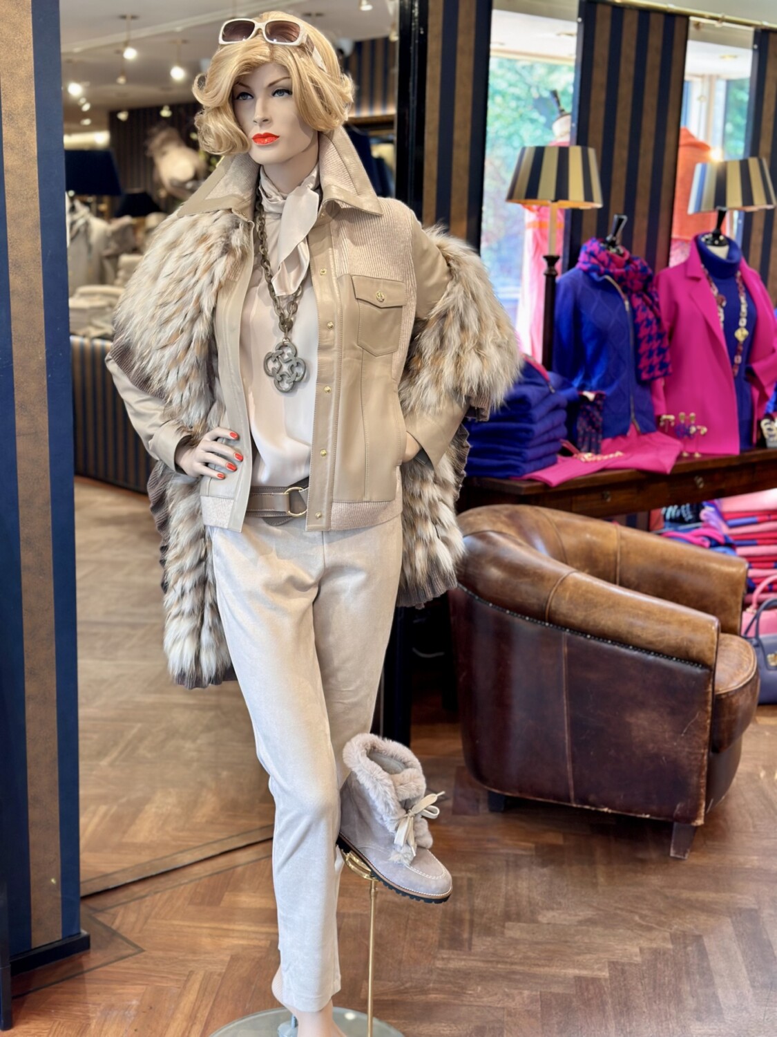 Modici mannequin met stijlvolle beigedamkleding, accessoires en schoenen in een boetiek.
