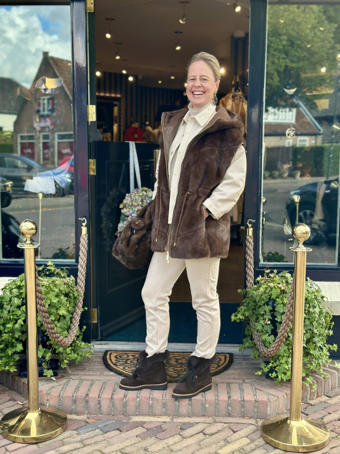 winterjas voor modieus boetiekje met gouden plekschermen en groene planten.