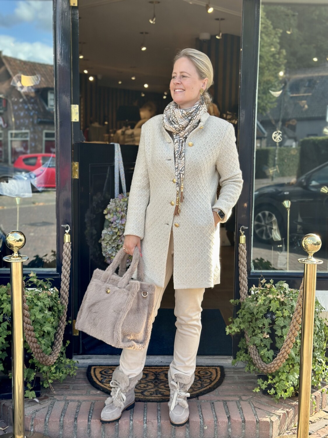 Luxe damesoutfit met beige jas en zachte tas voor elegante herfstlook.