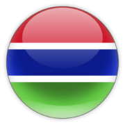 A round icon with the flag of Gambia, showing a horizontal tricolor of red, blue, and green with a white border between the colors, presented on a glossy spherical surface.